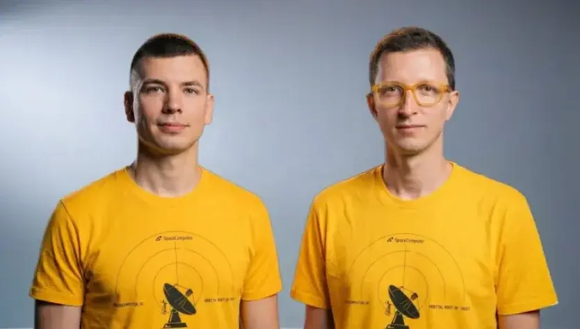Two SpaceComputer engineers in yellow mission shirts