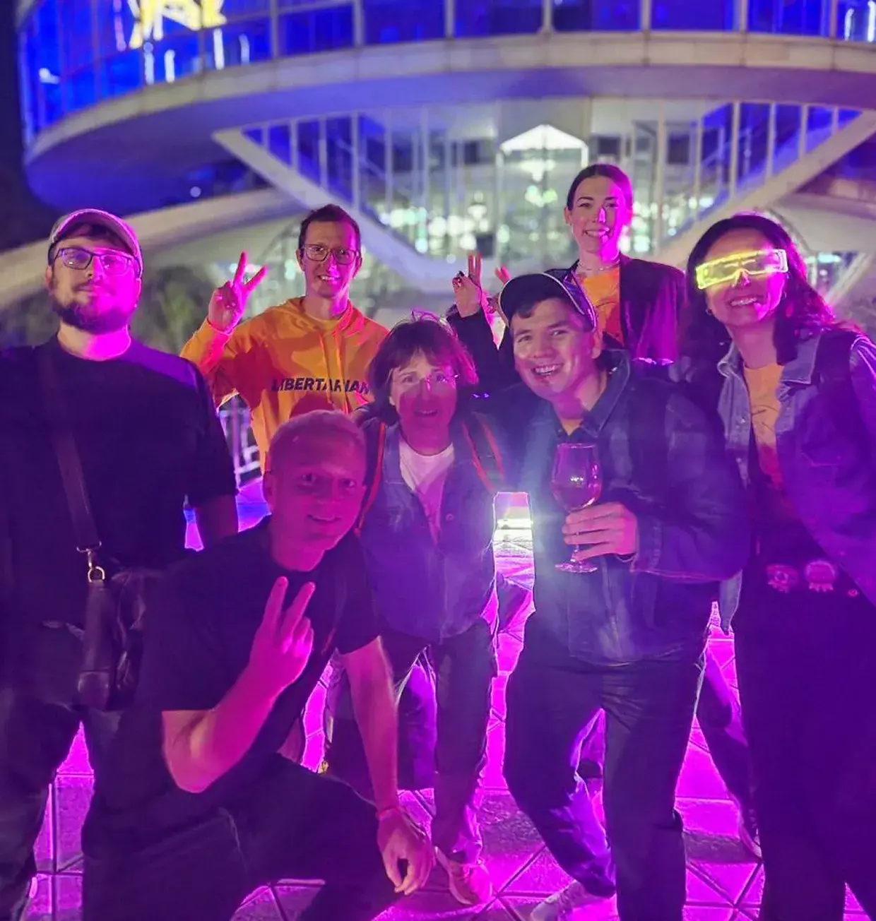 Team members at a night event under purple lighting